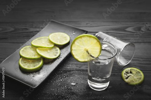 Shot glass with lemon and salt on black background