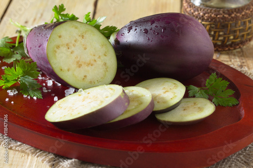 Eggplant close-up with fresh herbs, salt and vegetable oil on a