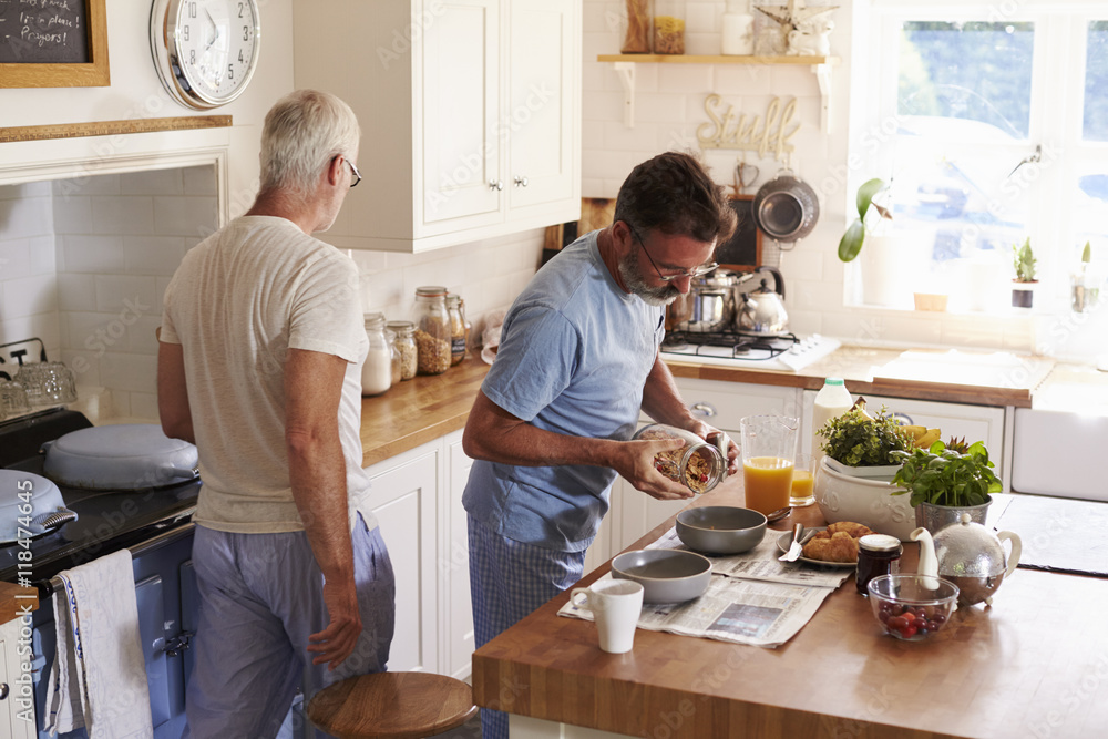 Male gay couple serving breakfast in their kitchen Male gay couple serving breakfast in their kitchen