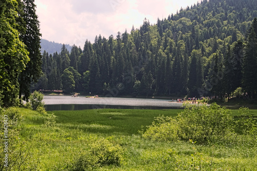 Morning in Lake Sinevir. Tourists are contemplateing the lake and its surroundings photo