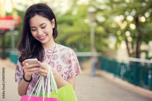 Happy young woman using cell phone at a shopping center