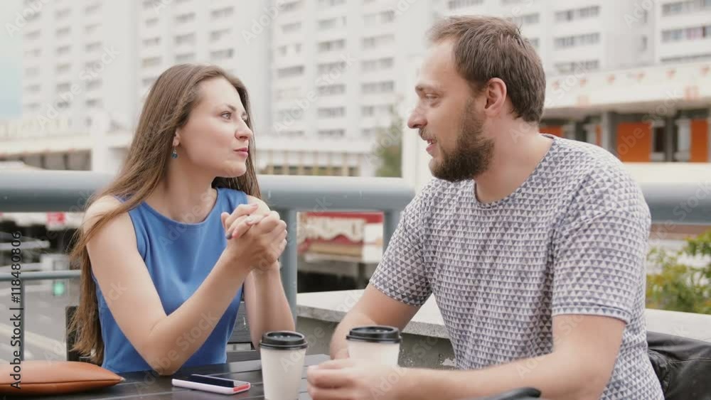 Young couple conversation in a cafe on the street, a woman emotionally tells something to the man. 4K