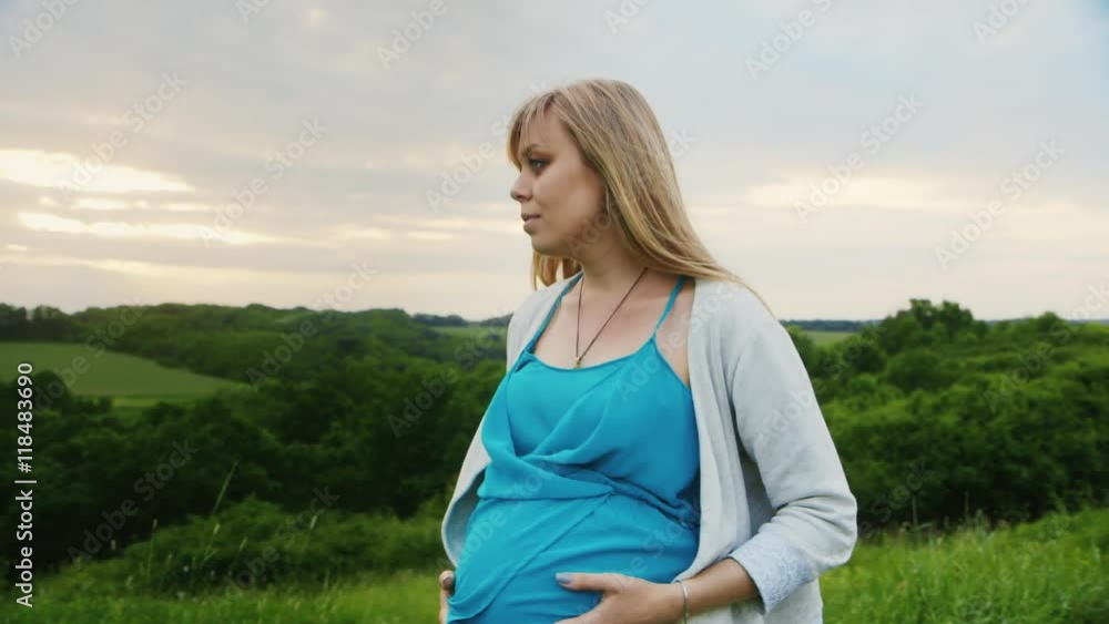 Steadicam shot: Pregnant woman walking in the scenic bridge on a background of green forest Steadicam shot: Pregnant woman walking in the scenic bridge on a background of green forest