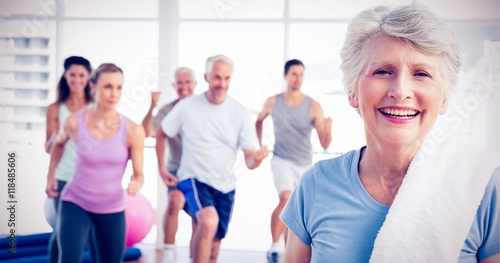 Senior woman with people exercising in fitness studio