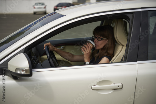 woman drinks coffee in the car © volodyar