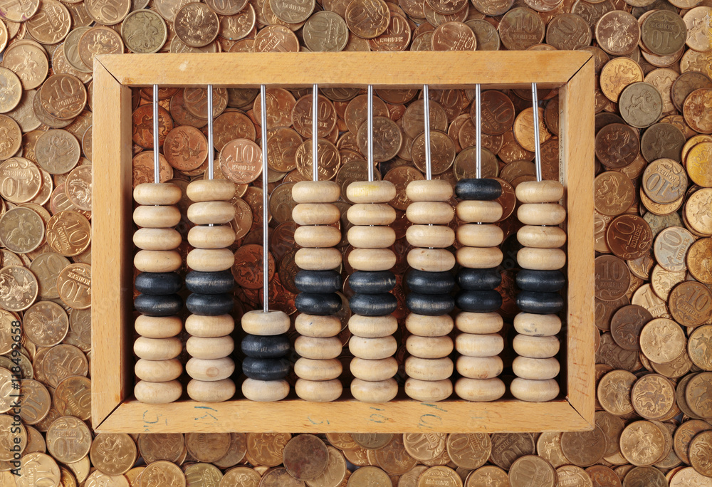 old wooden abacus on coins background old wooden abacus on coins background