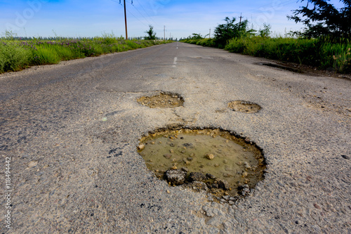 Holes on asphalt road photo