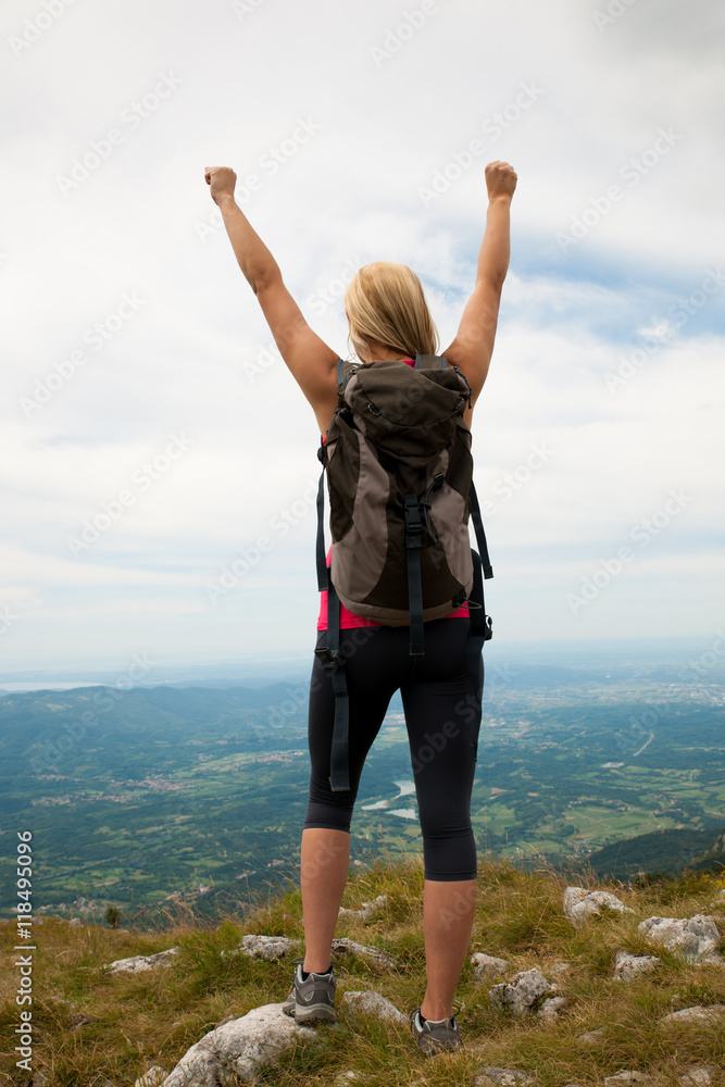 Trekking - woman hiking in mountains on a calm sumer day being Trekking - woman hiking in mountains on a calm sumer day being