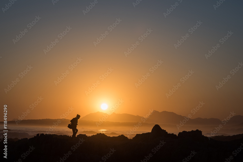 Persona osserva il tramonto sul mare