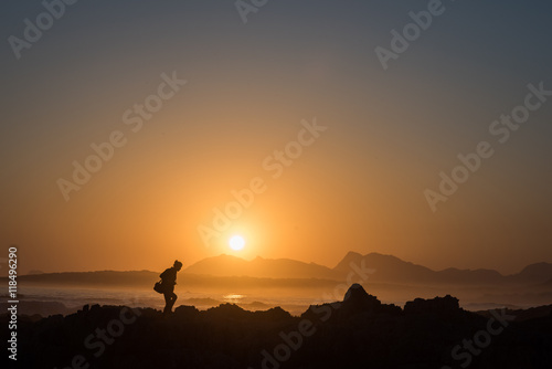 Persona osserva il tramonto sul mare