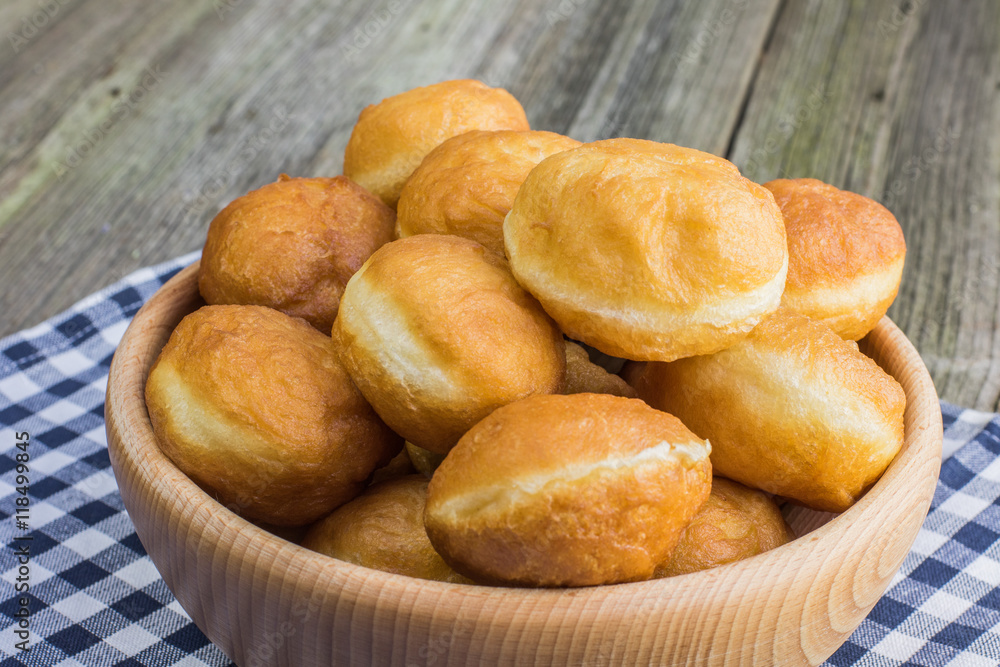 Many berliners (doughnut) in a wooden bowl Many berliners (doughnut) in a wooden bowl