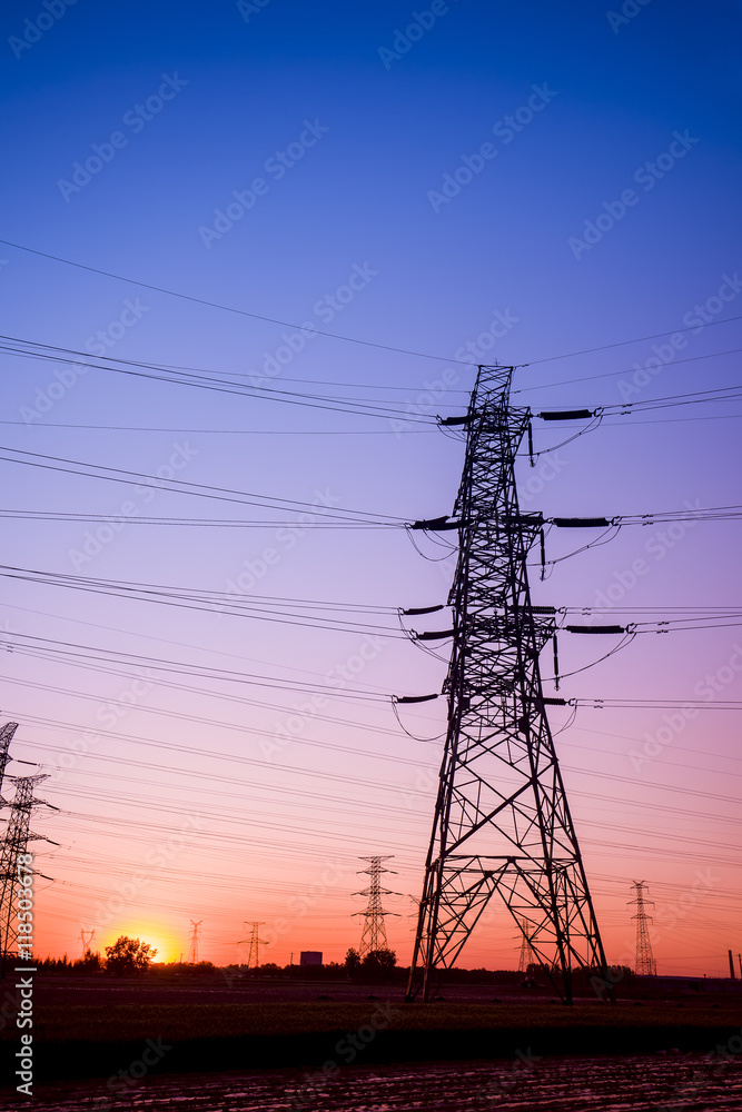 The silhouette of the evening electricity transmission pylon