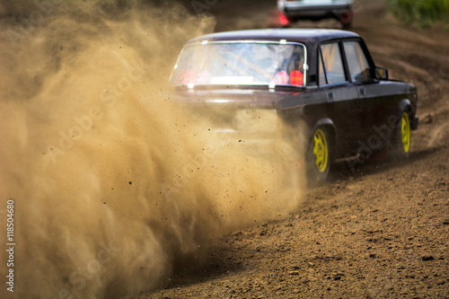 Autocross on a dusty road. Cars in the competition on a winding road photo