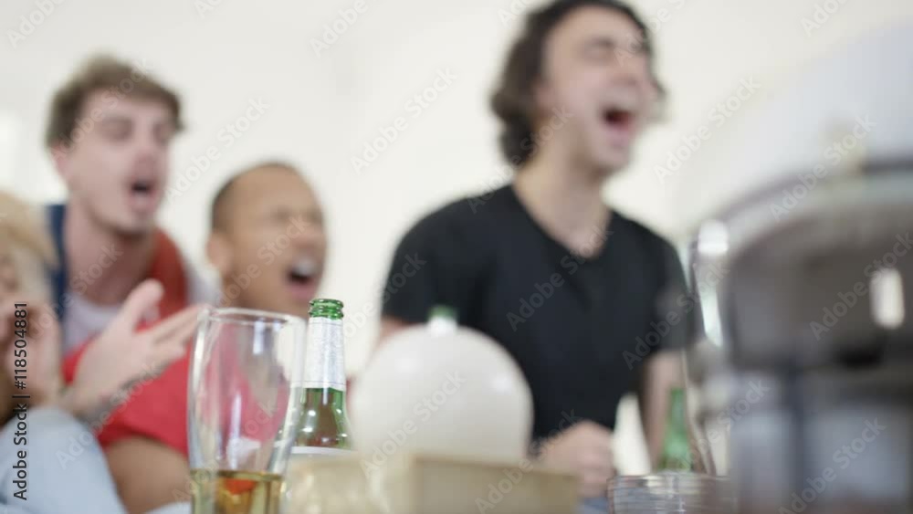 Group of friends hanging out together & watching American football game on TV Group of friends hanging out together & watching American football game on TV