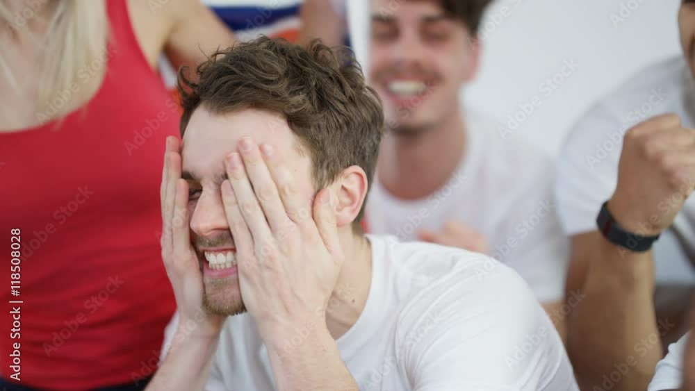Excited group of friends watching sports game on TV celebrate when team score Excited group of friends watching sports game on TV celebrate when team score