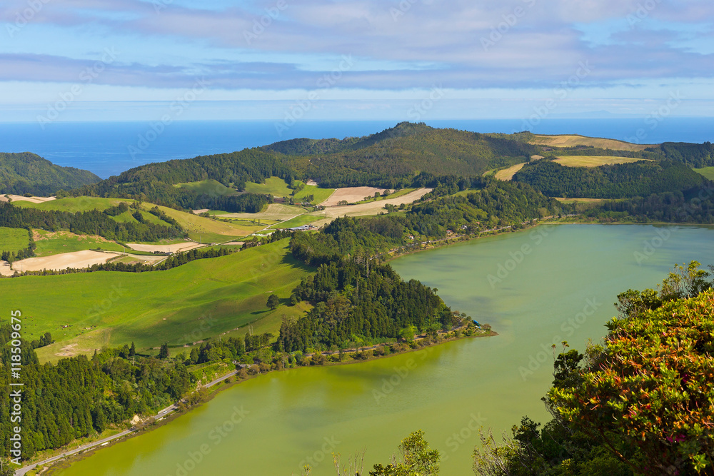 Aerial view on a volcanic lake and Atlantic Ocean on Sao Miguel Island, Azores, Portugal. Lagoa das Furnas lake panorama in summer.