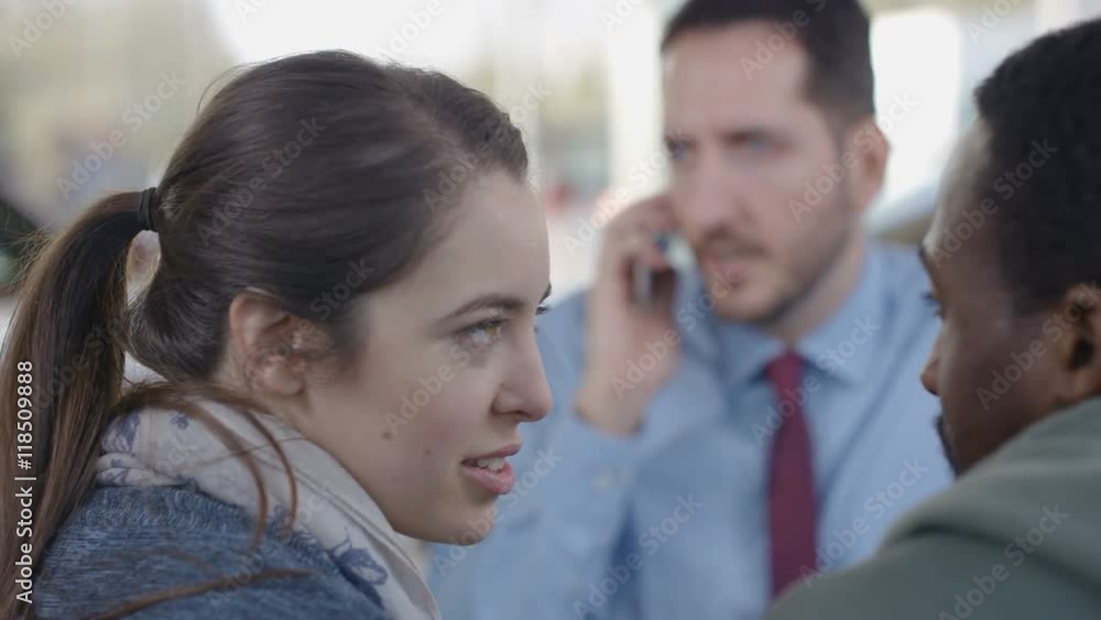 Salesman makes phone call while negotiating finance terms with couple Salesman makes phone call while negotiating finance terms with couple
