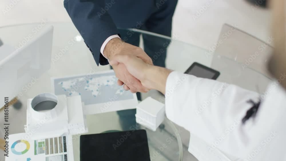 Close up on hands unrecognizable Arabic & businessmen shake hands on a deal Close up on hands unrecognizable Arabic & businessmen shake hands on a deal
