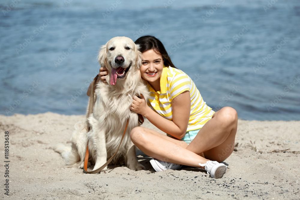 Beautiful girl with cute retriever on river shore Beautiful girl with cute retriever on river shore