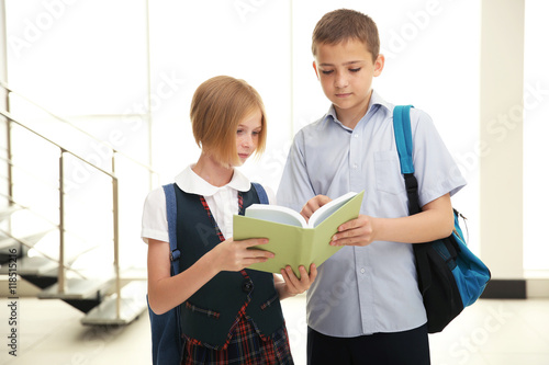 Cute schoolkids on light ba...
