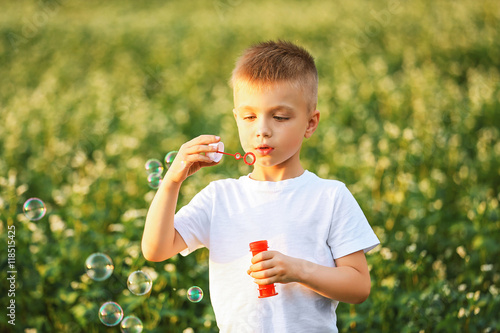 Little boy with bubbles in the field
