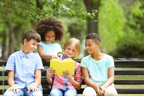 Cute kids reading book on b...