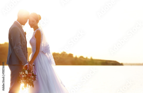 Groom and bride on sunset b...