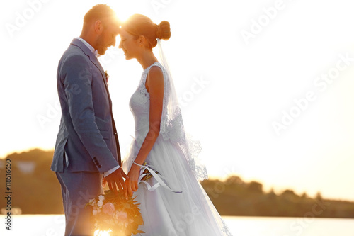 Groom and bride on sunset b...