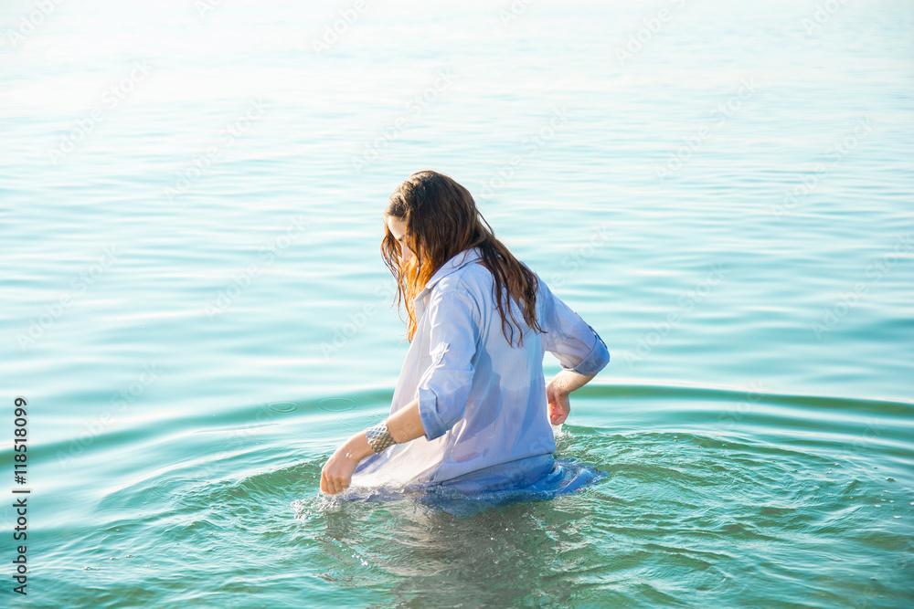 woman on sea get into the water in wet shirt woman on sea get into the water in wet shirt