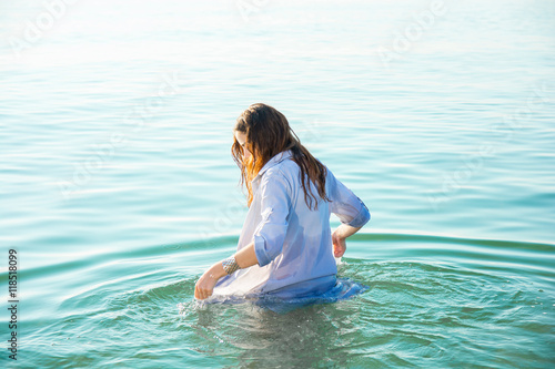 Tablou pe pânză woman on sea get into the water in wet shirt