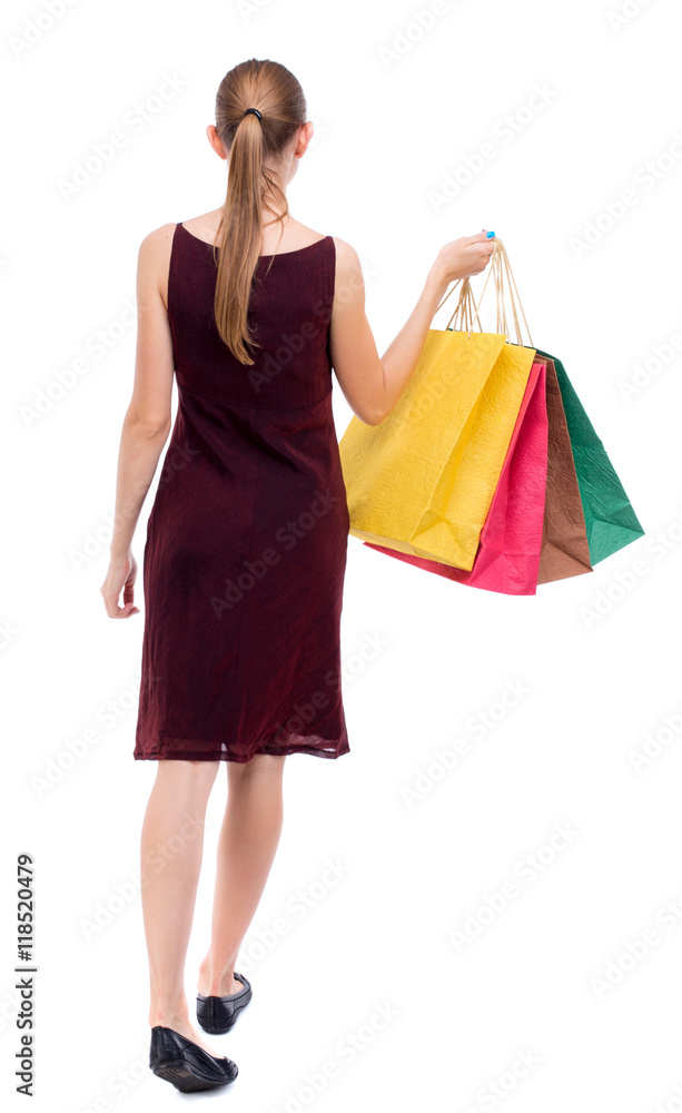 back view of going  woman  with shopping bags . beautiful girl in motion.  backside view of person.  Rear view people collection. Isolated over white background. The girl in the maroon sleeveless