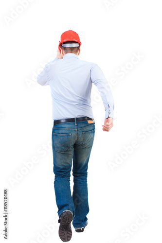 Back view of running engineer in helmet. Walking guy in motion. Rear view people collection. Backside view of person. Isolated over white background. Bearded businessman in a white shirt and a helmet