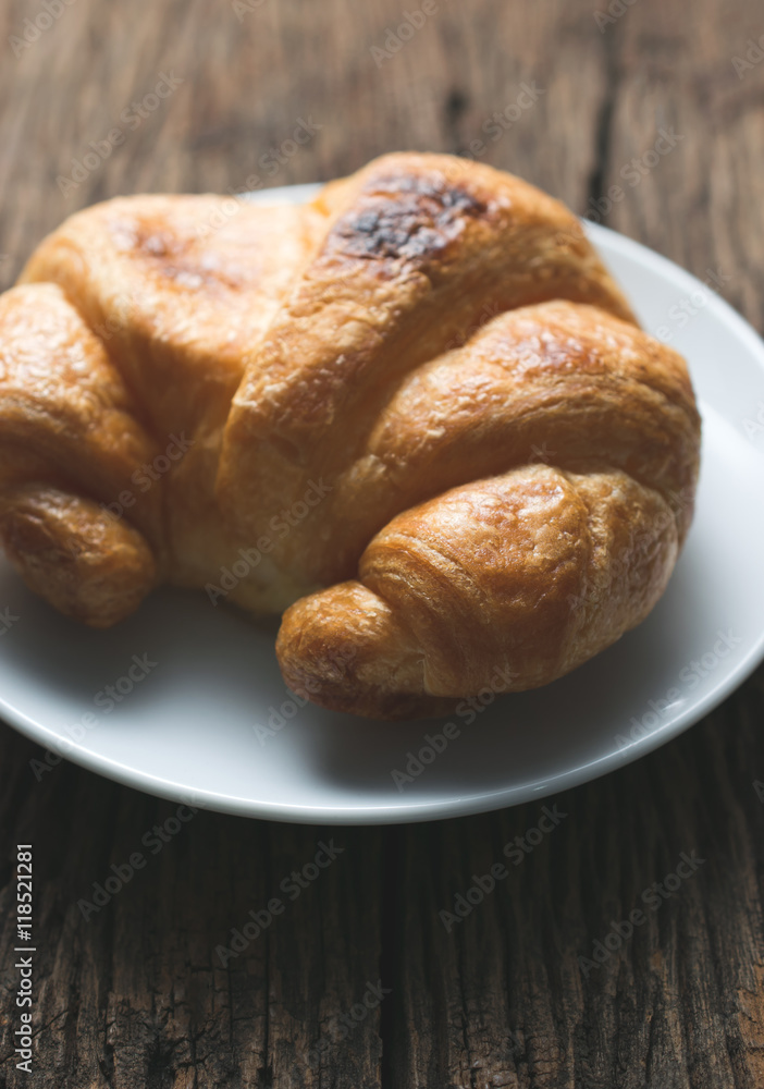 Fresh baked croissants on wood table from above