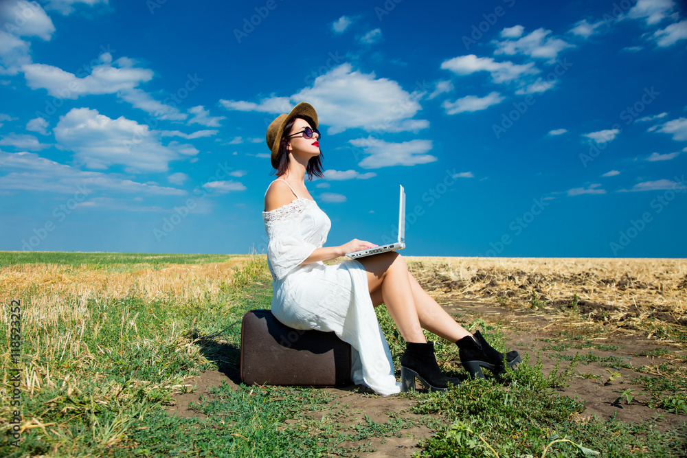 young woman with suitcase and laptop