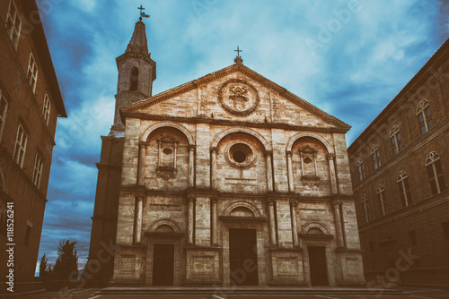 Twilight view of the Pienza Assumption of the Virgin Mary Cathedral with dark blue sky. Facade from white marble. Religious travel destinations background.