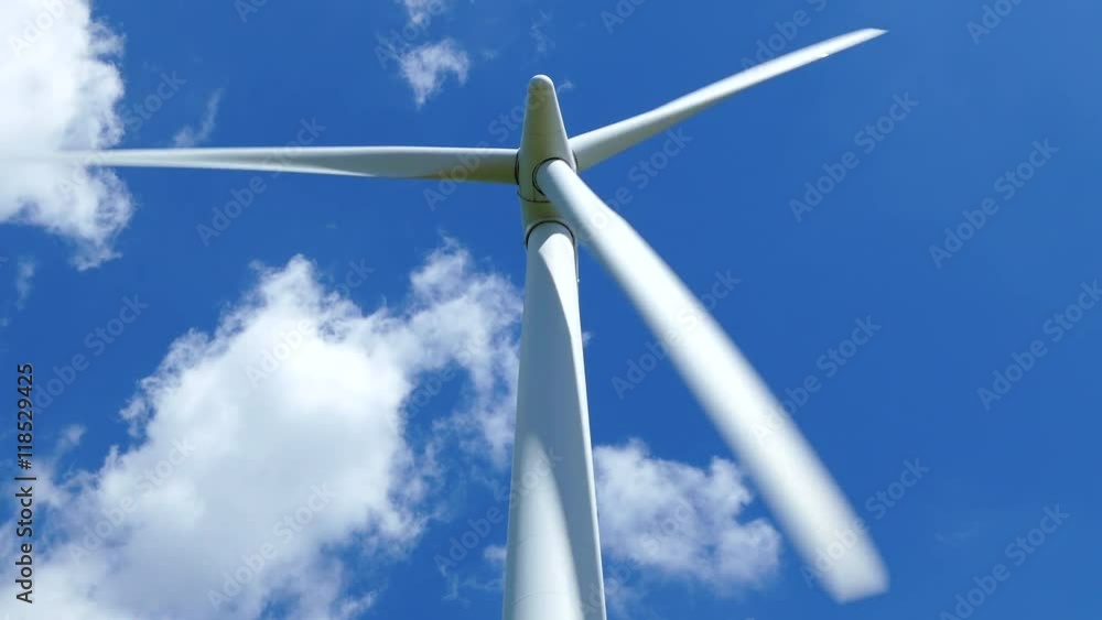 Single turning wind turbine against a blue sky summers day looking straight up Single turning wind turbine against a blue sky summers day looking straight up