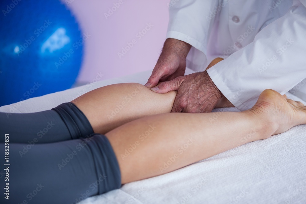 Physiotherapist giving leg massage to a woman Physiotherapist giving leg massage to a woman