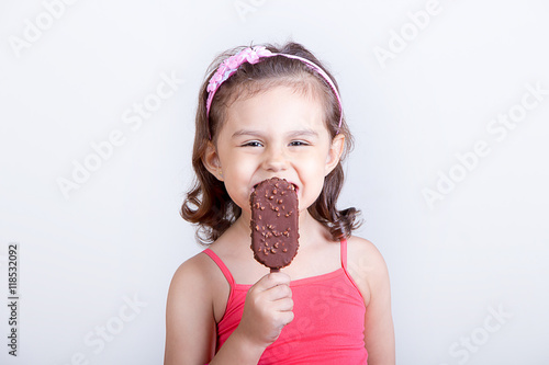 Young girl feeling happy while eating chocolate ice cream bar