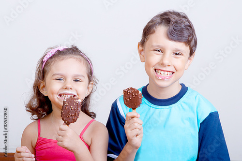 Young boy and girl feeling happy while eating chocolate ice crea