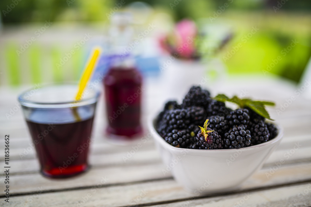 Fresh blackberries in bowl on wooden table in the garden Fresh blackberries in bowl on wooden table in the garden