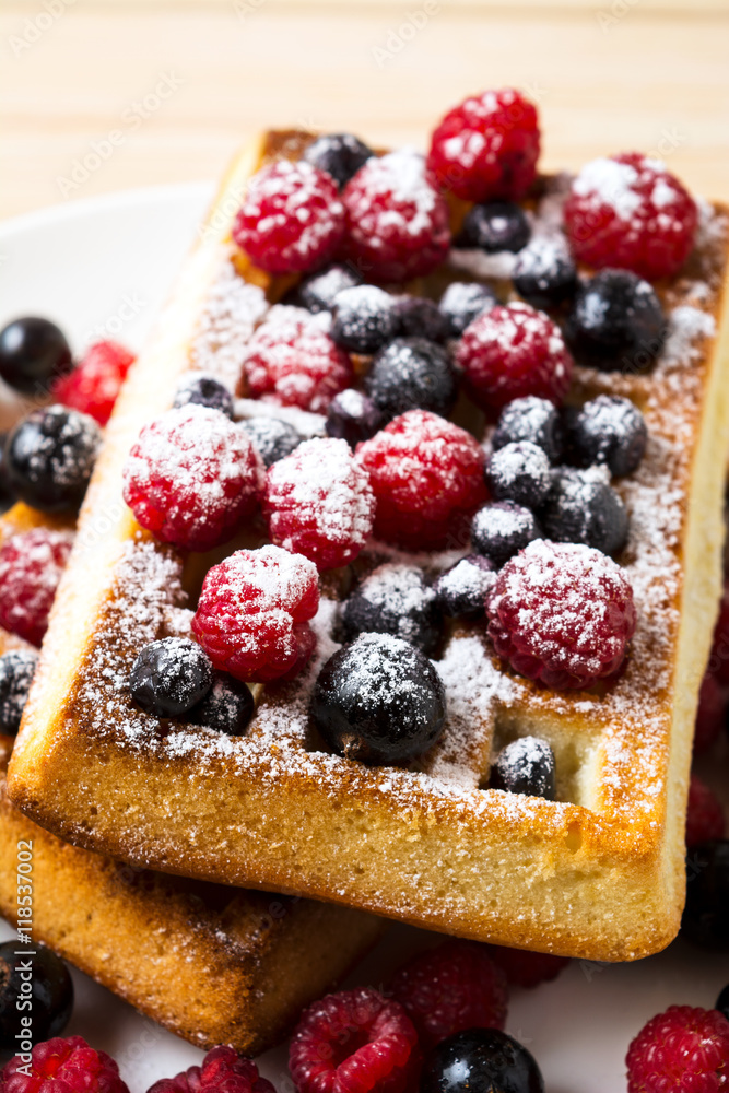 Belgian waffles with fresh berries powdered by caster sugar Belgian waffles with fresh berries powdered by caster sugar