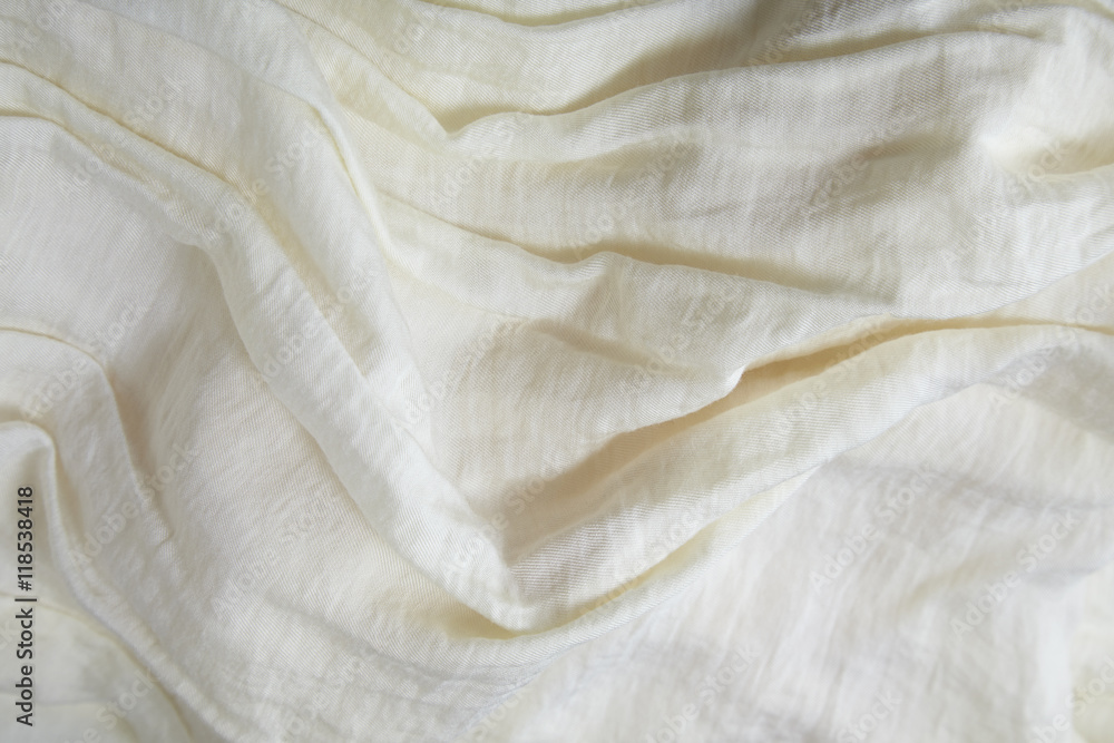 A full page close up of creased cream colored fabric texture