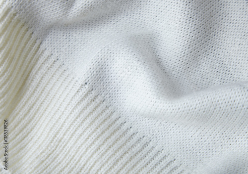 A full page close up of cream knitted sweater fabric texture with ribbed cuff