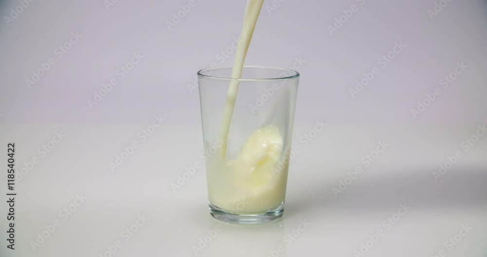An empty glass is standing on a kitchen counter. Someone is pouring some vanilla drink into it so that the glass is full. Wide-angle shot.
An empty glass is standing on a kitchen counter. Someone is pouring some vanilla drink into it so that the glass is full. Wide-angle shot.