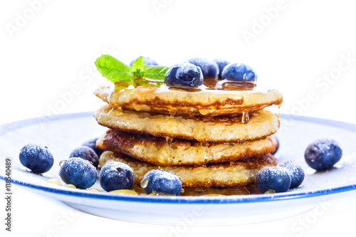 Pile of pancakes with blueberries sprinkled with icing sugar and