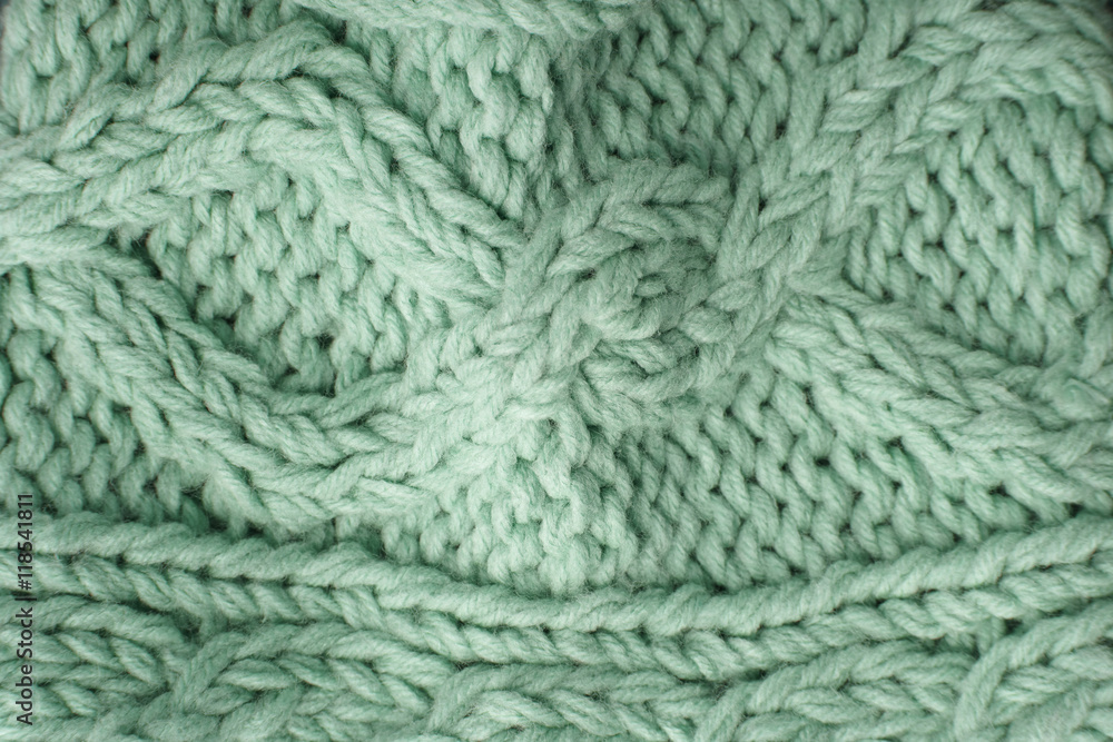 A full page close up of pastel green knitted sweater fabric texture A full page close up of pastel green knitted sweater fabric texture