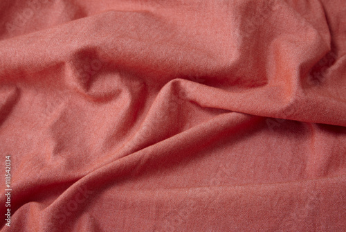 A full page close up of creased brick red shirt fabric texture
