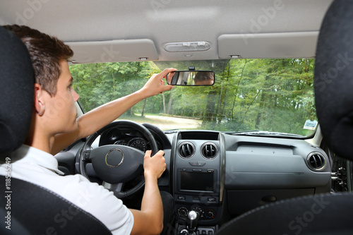 Quadro em tela Man adjusting his mirror in a car