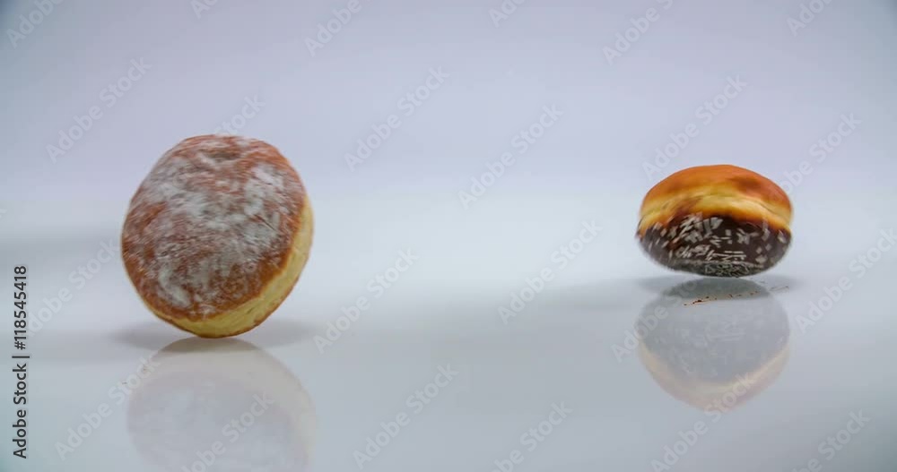 Three doughnuts are falling down on a kitchen counter and they are staying there. Wide-angle shot.
Three doughnuts are falling down on a kitchen counter and they are staying there. Wide-angle shot.