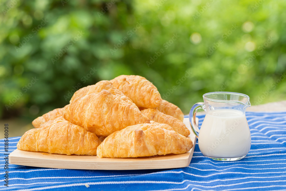 fresh croissants with milk on wooden table fresh croissants with milk on wooden table